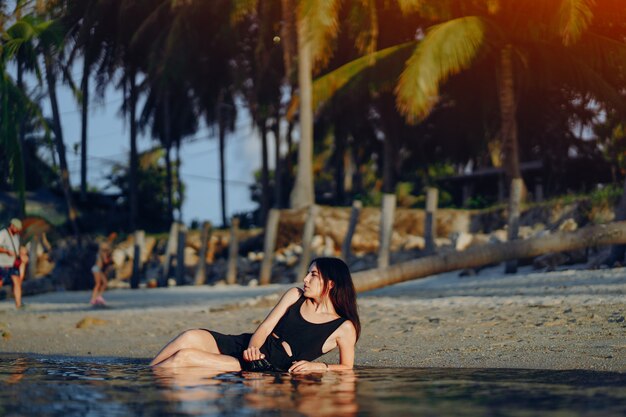 Fille portant dans l&#39;eau sur la plage en Thaïlande