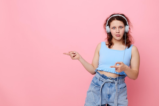 Fille portant des écouteurs danse mouvement divertissement fond rose inchangé