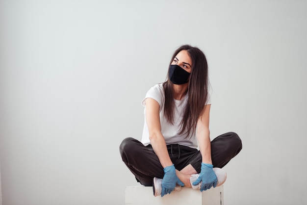 Une fille portant un masque facial et des gants chirurgicaux