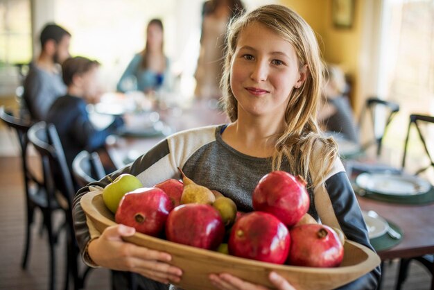 Une fille portant un panier de pommes