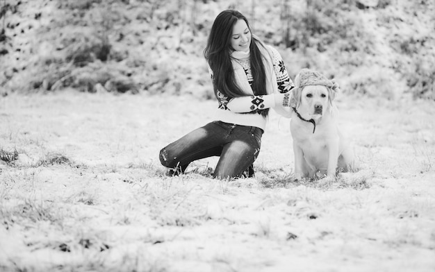 La fille porte un chapeau d'hiver sur le chien