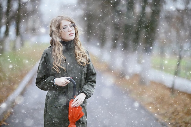 fille portrait romantique première neige automne, flocons de neige arrière-plan flou hiver saisonnier