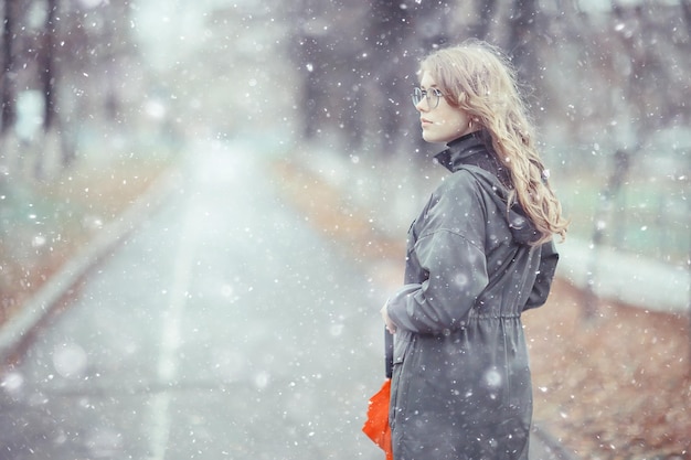 fille portrait romantique première neige automne, flocons de neige arrière-plan flou hiver saisonnier