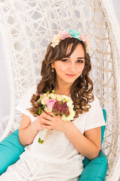 Fille Posant Dans Une Couronne Décorative De Fleurs Artificielles Et Bouquet à L'intérieur