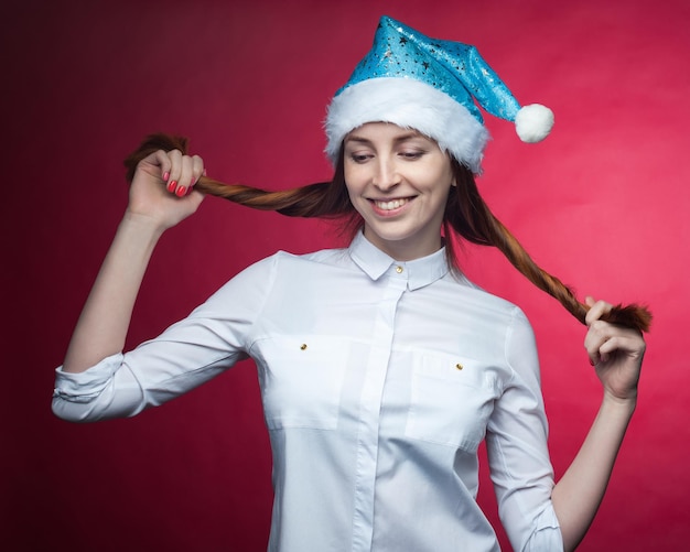 Photo fille posant en studio sur fond rose dans un chapeau de noëlxa