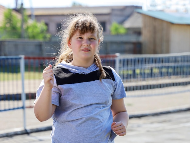 Une fille potelée en tenue de sport se précipite pour le portrait de gros plan de sport