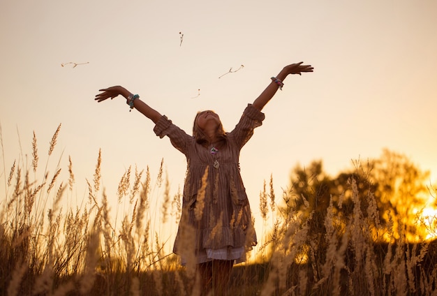 Fille sur Prairie avec coucher de soleil