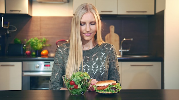 Fille préférant la salade au hamburger.