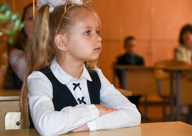 Une fille de première année est assise à son bureau à l'école.