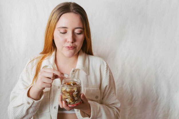 Fille prenant un morceau de fruit sec d'un verre