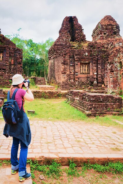 Photo fille prenant une photo des ruines des anciens temples hindous de my son, vietnam