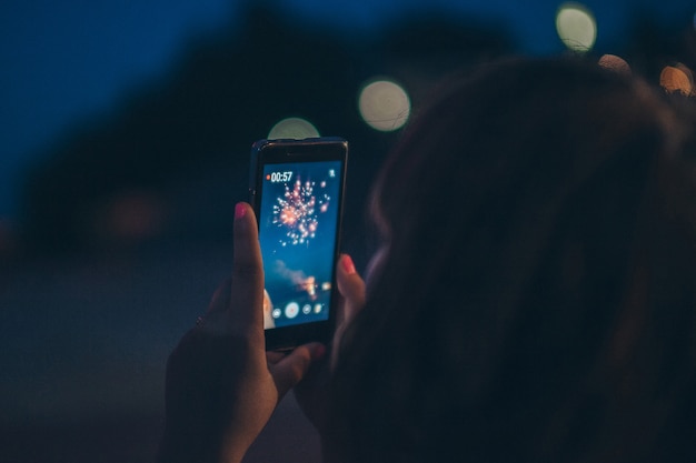 Fille prenant une photo de tir au feu d&#39;artifice