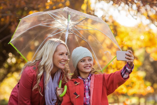 Fille prenant selfie avec mère au parc