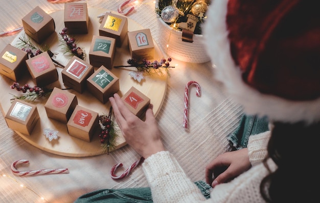 Fille prend une boîte de calendrier de l'avent sur le lit