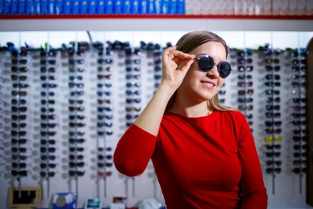 Photo la fille prend des lunettes de soleil. boutique de lunettes. correction de la vue. porte-lunettes