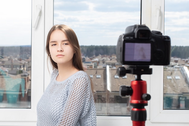Une fille prend une vidéo d'elle-même à la maison devant une caméra