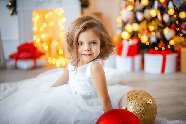 Fille près de l'arbre de Noël