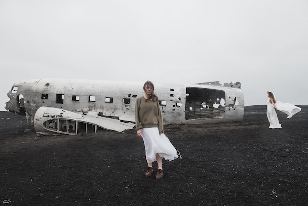 Photo fille près de l'avion sur solheimasandur en islande