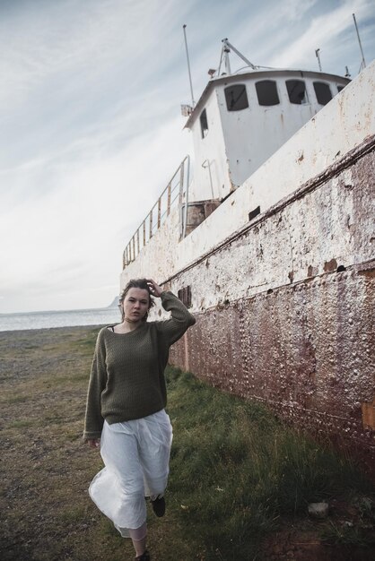 fille près de l'immense navire en Islande