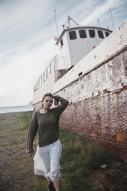 fille près de l'immense navire en Islande