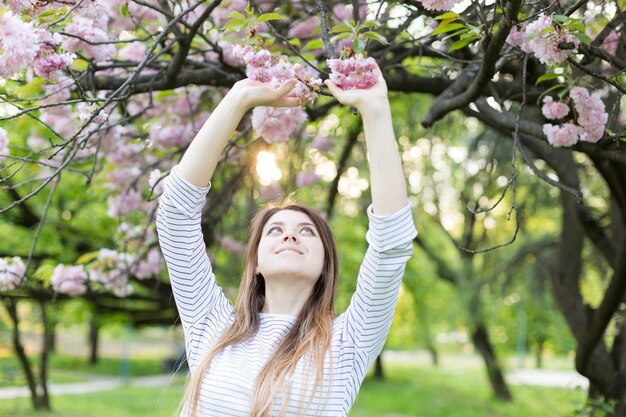 fille près de sakura en fleurs Le printemps est maintenant Fleurs de cerisier Sakura au crépuscule portrait au coucher du soleil