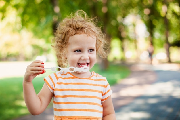 Fille princesse soufflant des bulles de savon avec le concept de l&#39;enfance heureuse en forme de coeur