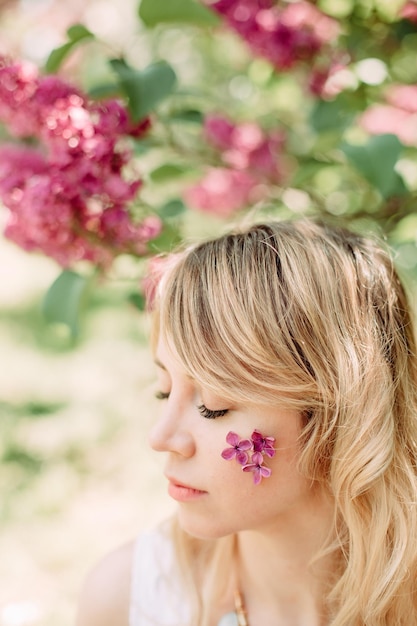 Fille printemps fleurit sa joue arbre sakura