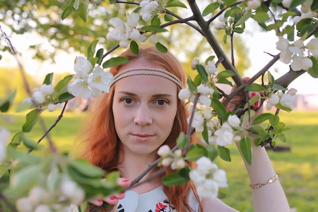 Une fille en promenade dans un parc en automne. Jeune fille rousse au printemps sur la nature.