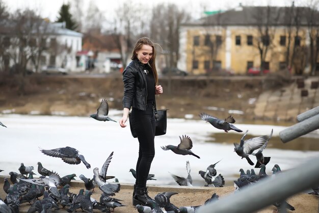 Une fille en promenade dans le parc et un troupeau de pigeons