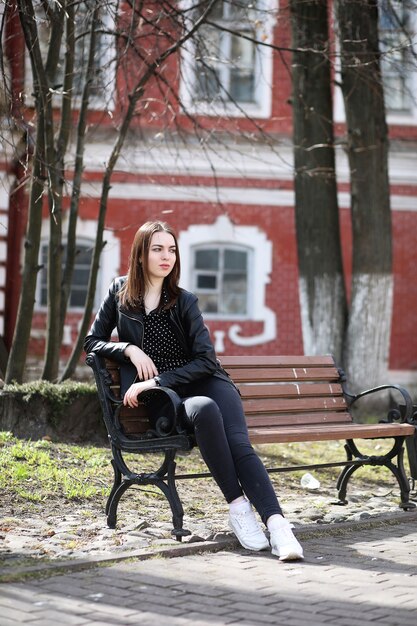 Fille sur une promenade à travers la ville de printemps par une journée ensoleillée