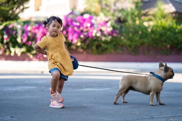 Une fille promène son chien en laisse