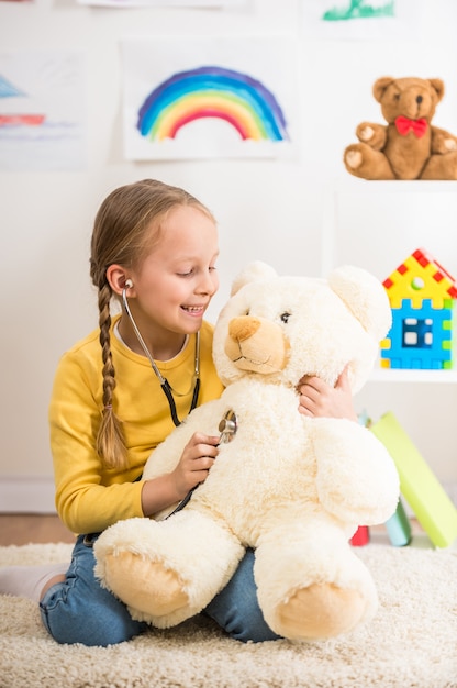 Fille en pull jouant avec ours