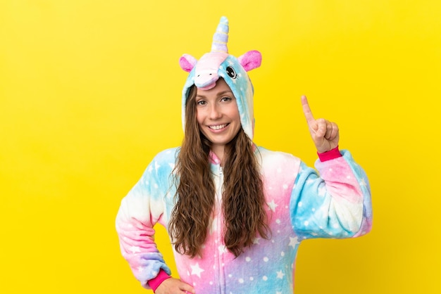 Fille avec pyjama licorne sur fond isolé montrant et levant un doigt en signe du meilleur