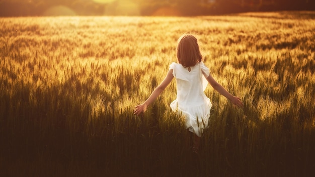 Fille qui court sur un champ de céréales