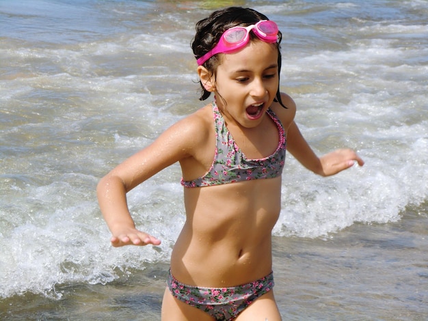 Photo une fille qui court sur la plage.