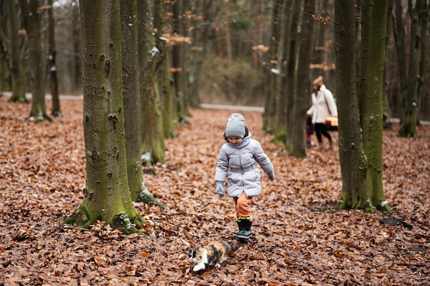 Fille qui marche avec un chaton en plein air au bois