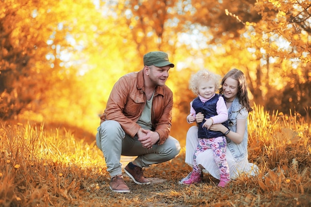 Fille qui marche dans le parc en automne. Automne dans la ville, fille avec papa pour une promenade. Les parents marchent avec les petits enfants. Les gens du parc d'automne