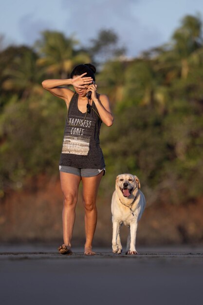 Une fille qui parle au téléphone avec un chien.