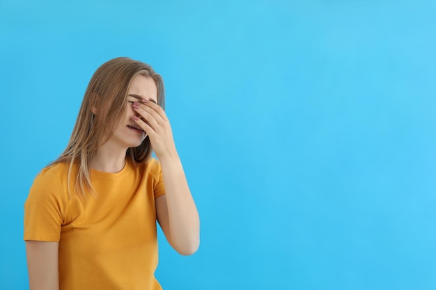 Fille qui pleure en t-shirt sur fond bleu