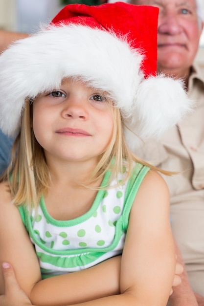 Fille qui porte le bonnet de Noel à la maison