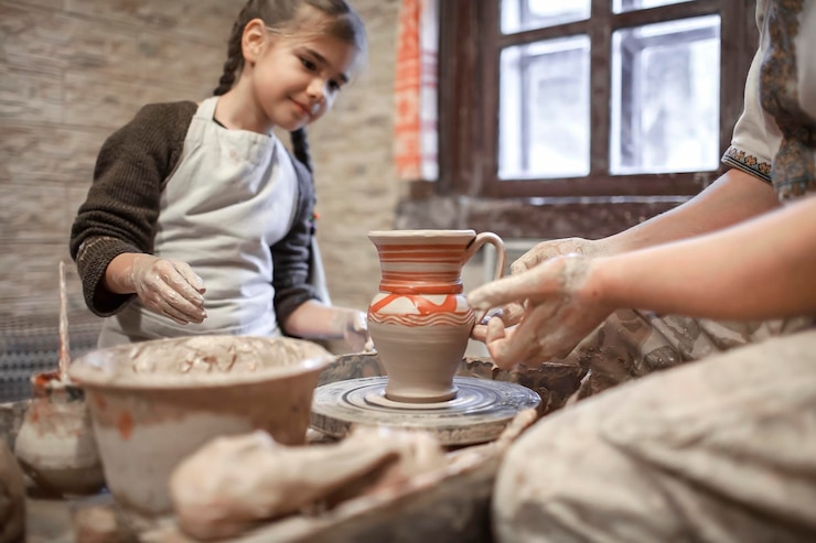 Photo une fille qui regarde un potier dans un atelier.
