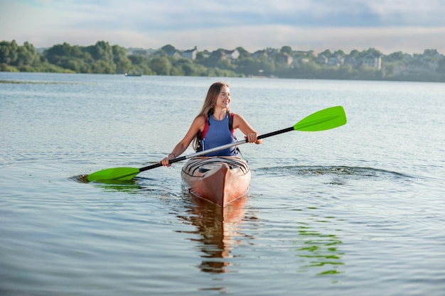 Fille ramant un kayak sur le lac Une fille dans un canoë lors d'une excursion aquatique Passe-temps actif