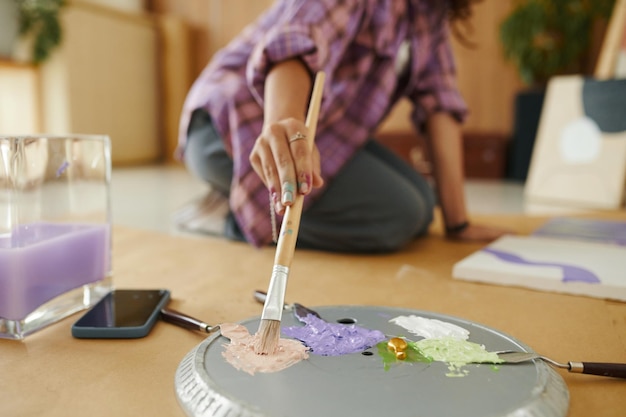 Photo une fille ramassant de la peinture sur un pinceau