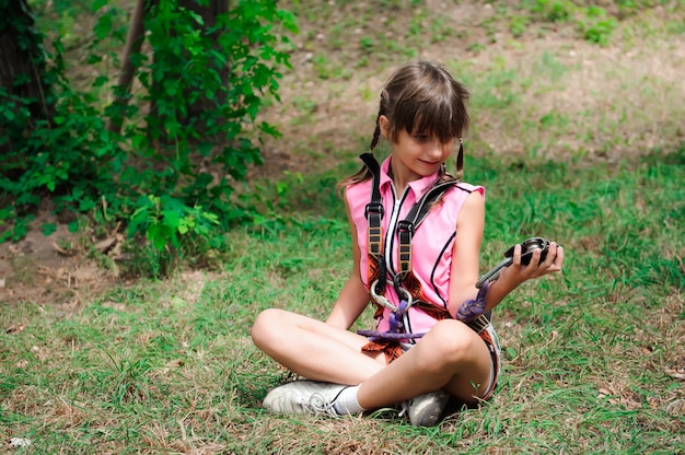 Fille de randonnée dans le parc de corde en équipement de sécurité