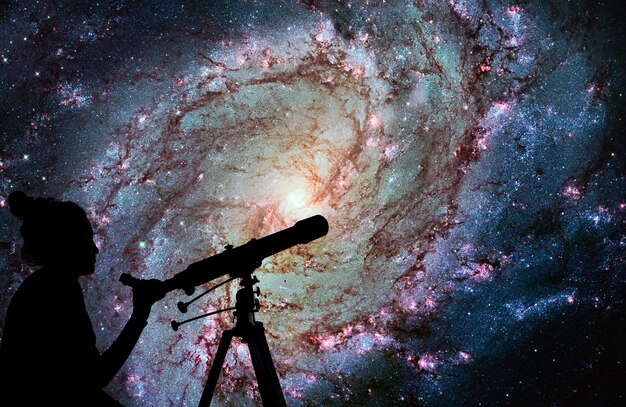 Photo fille regardant les étoiles avec un télescope. messier 83, southern pinwheel galaxy, m83 dans la constellation de l'hydre. les éléments de cette image sont fournis par la nasa.