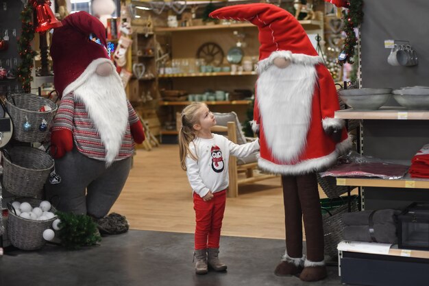 Photo fille regardant le père noël dans un magasin avec des jouets et des décorations