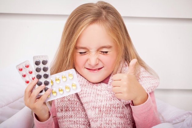 Fille regardant les pilules contre le rhume et la grippe