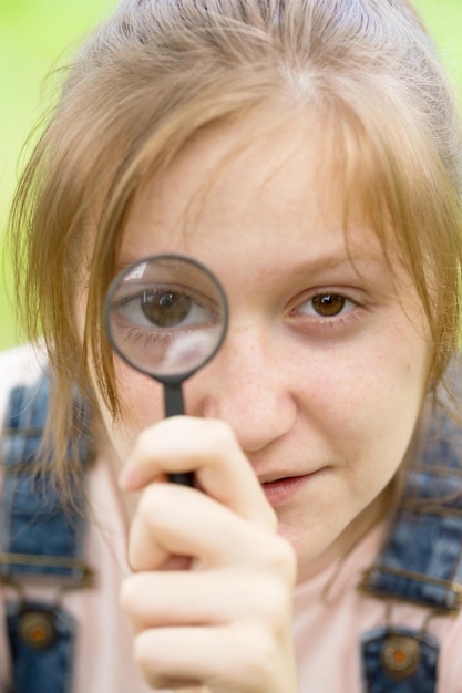 Fille regardant à travers une loupe