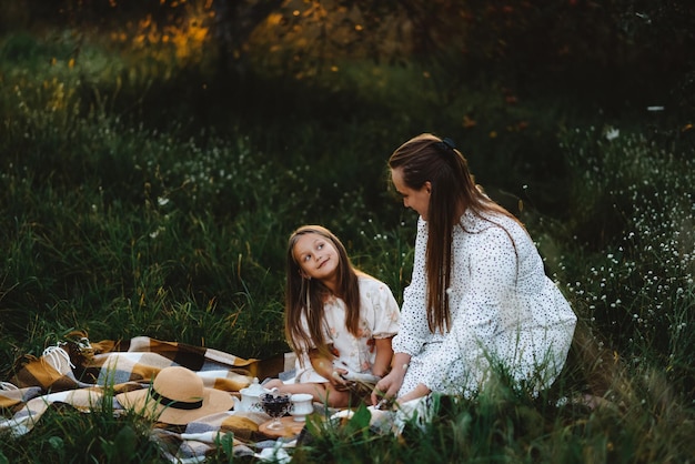 La fille regarde sa mère en attendant un autre morceau de gâteau