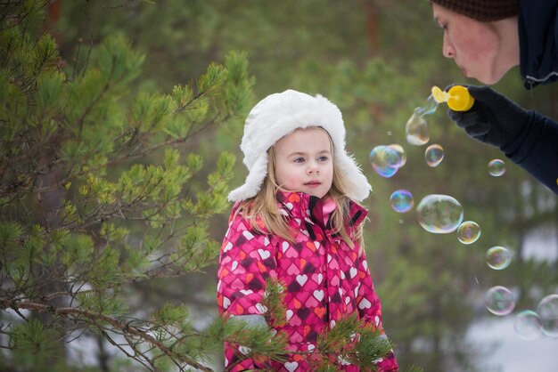 Photo la fille regarde sa mère souffler des bulles